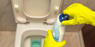 Child Resistant Closure cleaning product being held over a toilet