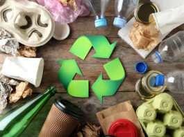 New Valpak service aims to help businesses prepare for PPWR Recycling symbol and different garbage on wooden background, top view