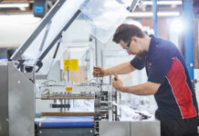 Greener packaging machinery for improved sustainability Engineer maintaining packaging machinery