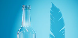 Empty glass bottle next to a feather to depict lightness