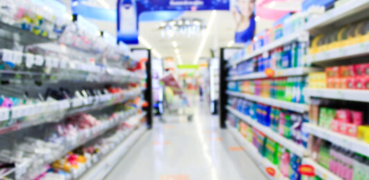 Supermarket in blurry background displaying various types of packaging